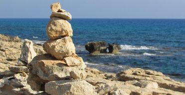 stack of stones on seashore, cyprus, cape greko national park