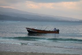 fisherman in a boat in the evening sea