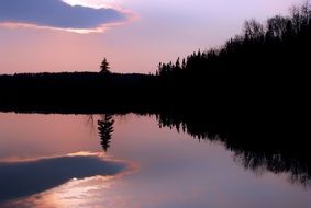 reflection of a purple sunset in a lake in Quebec Canada