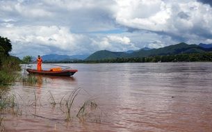 orange Monk on Boat in River scene