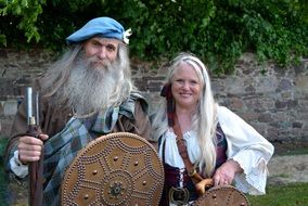 costumed old bearded man and young blonde long haired girl, Highland Games, uk, Scotland