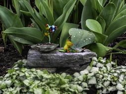 figures of funny frogs in the design of the garden