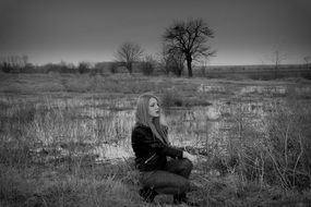 Black and white photo of a girl on the background of the swamp