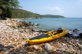 landscape of yellow kayak on a picturesque beach on a sunny day