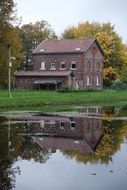 wooden house among nature is reflected in the water