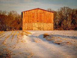 wooden Barn near harvested field at Winter