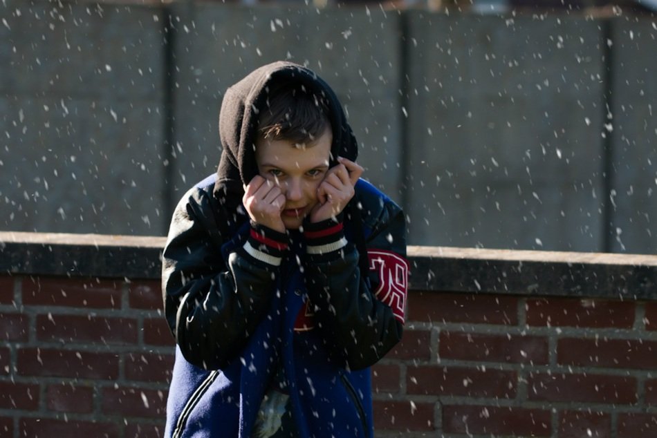 frozen young man under snowfall