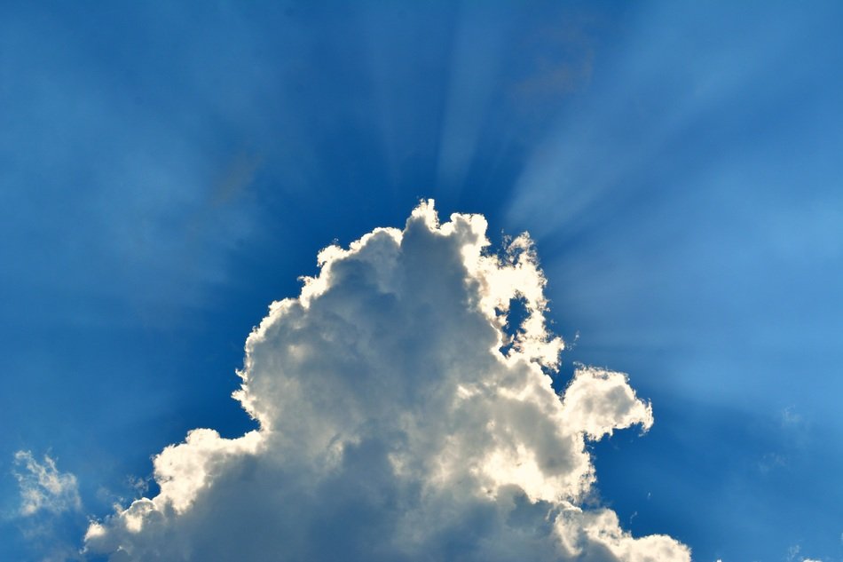 the sun behind a white cloud in the sky
