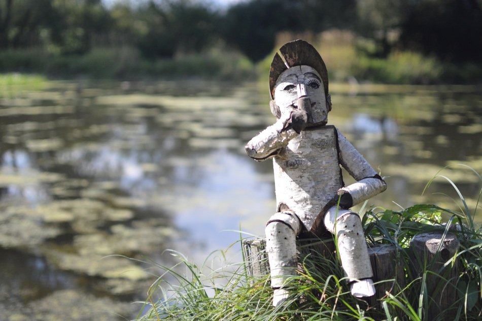 wooden doll by the lake close-up