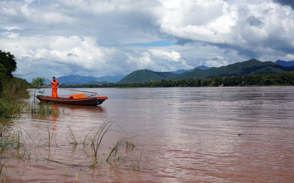 orange Monk on Boat in River scene