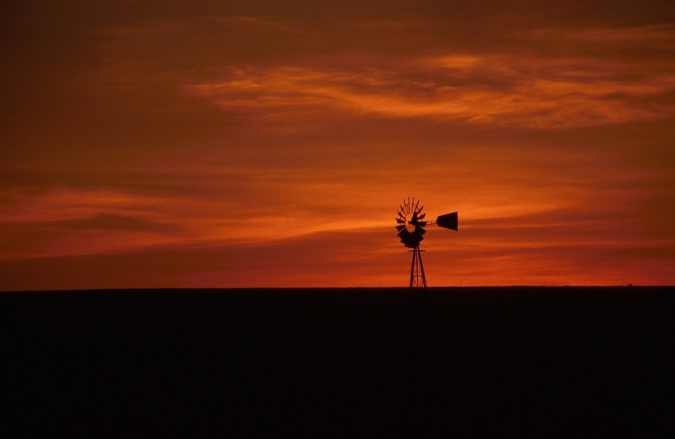 windmill against the orange sky at dusk