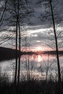distant view of pink sunset over a lake in finland