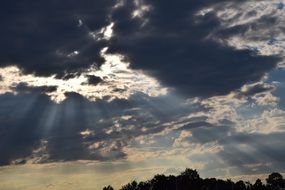 bright sunbeams through dark clouds