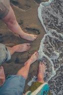 bare feet on the sand at the edge of water of the pacific