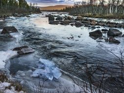 frozen river with stones at dusk