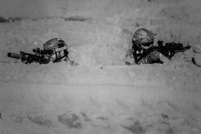 two military men with weapons in the desert