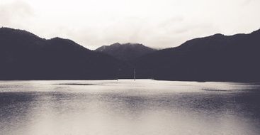 lake between hills in black and white image