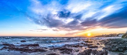 colorful Sunset sky above rocky coastline