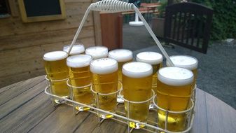 Basket with Foamy Beer in Glasses on table