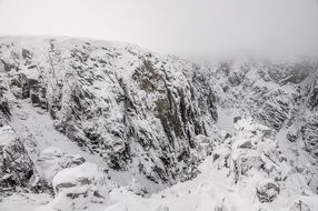 rocks in the snow in cloudy haze