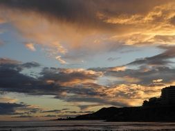 dark and bright Clouds at Sunset Sky above coastline