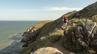 tourist on a trail on the rocky coast of santa catarina in brazil