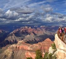 gorgeous landscape with people looking at Grand Canyon beneath Storm Clouds, usa, arizona