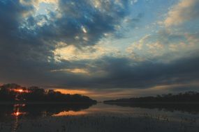 the end of a bright sunset in a quiet river