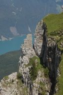 green rocks on a background of blue mountain lake
