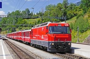 red train on the rhaetian railways in switzerland