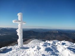 Landscape of frozen cross on a mountain peak, poland