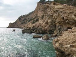 Sea at rocky coast on cloudy weather