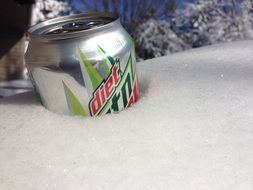 tin can with a drink in the snow close-up