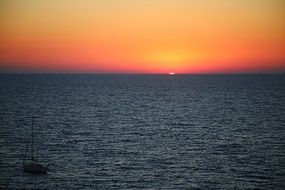 distant view of the rising sun on the horizon in the sea