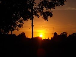 windmill and trees silhouettes at Sunset Orange sky