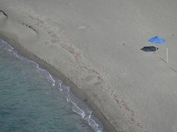 lonely blue umbrella on a sandy beach