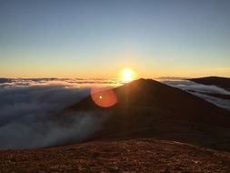 sun at sunset over the top of the mountain