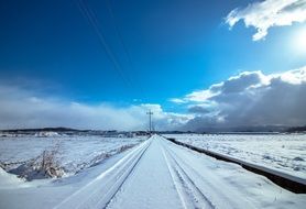 road in the snow under a blue sky in winter