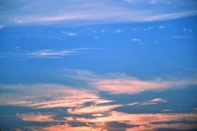 pink clouds in bright blue sky