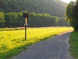 direction sign on Meadow at path through forested mountains