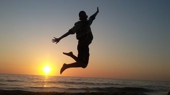 man jumping on sunset background