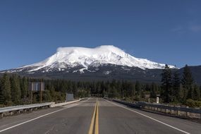 road against the backdrop of a mountain with snow on top