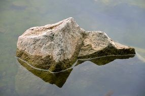Stone as Island in calm water