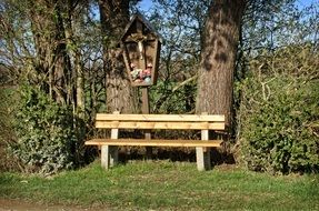 wooden bench for rest near a roadside cross