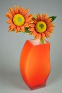 two orange flowers in a vase as a still life