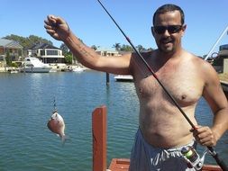 fishing with a catch in hand at the pier