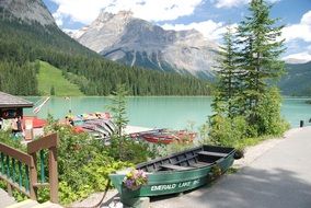 boats near the shore of an emerald lake in canada