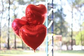 three red Heart form balloons outdoor