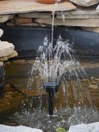 small fountain in a decorative pond