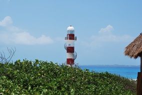 lighthouse behind a green hill in mexico